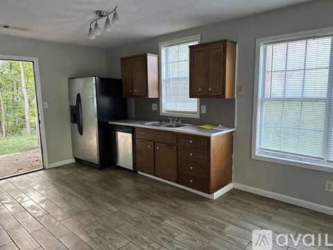A kitchen with wooden cabinets and a tile floor.