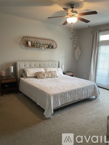 A bedroom with a large bed and a ceiling fan.