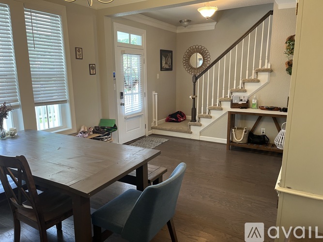 A dining room with a wooden table and chairs.