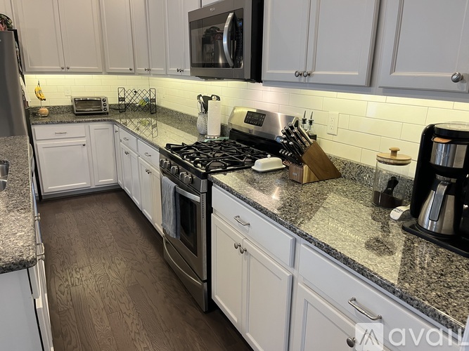 A kitchen with white cabinets and a granite countertop.