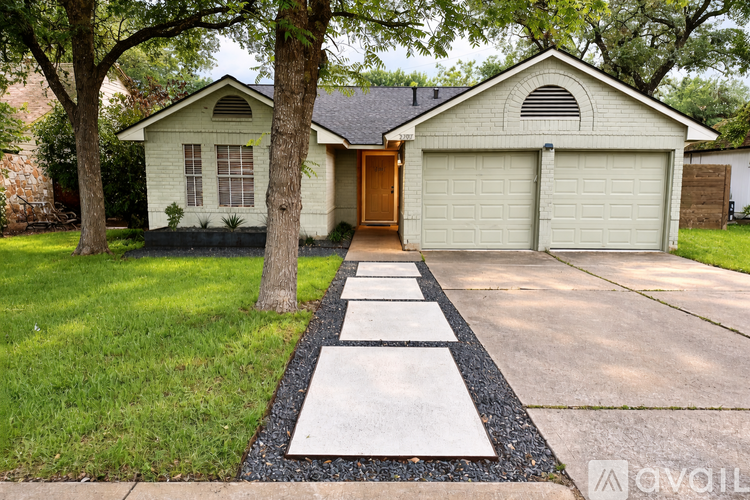 A house with a brown door and two garage doors.
