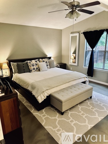 A bedroom with a large bed and a ceiling fan.