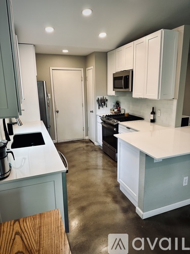 A kitchen with a white counter top and a refrigerator.