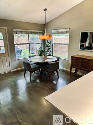 A dining room with a table and chairs.