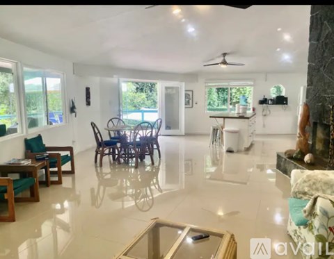 A living room with a glass table and a ceiling fan.