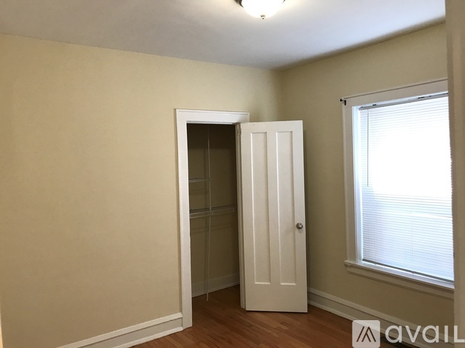 A room with a white door and a window with blinds.