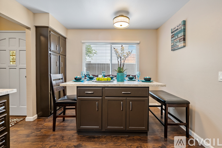 A kitchen with a table and chairs.