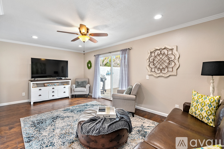 A living room with a brown leather couch and a white entertainment center.