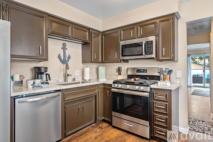 A kitchen with brown cabinets and a stainless steel refrigerator.