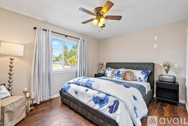 A bedroom with a large bed and a ceiling fan.