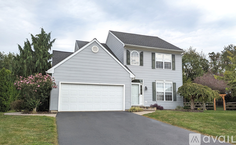 A house with a grey siding and a white garage door.