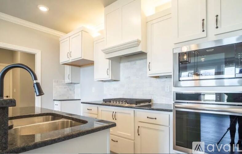 A modern kitchen with a stainless steel sink and oven.