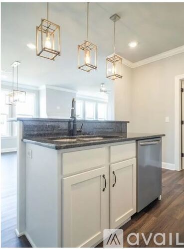 A kitchen with a granite countertop and white cabinets.