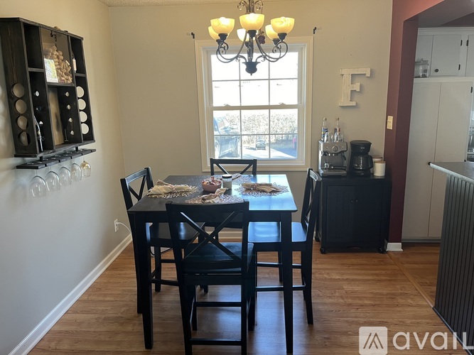 A dining room with a table set for two and a chandelier.