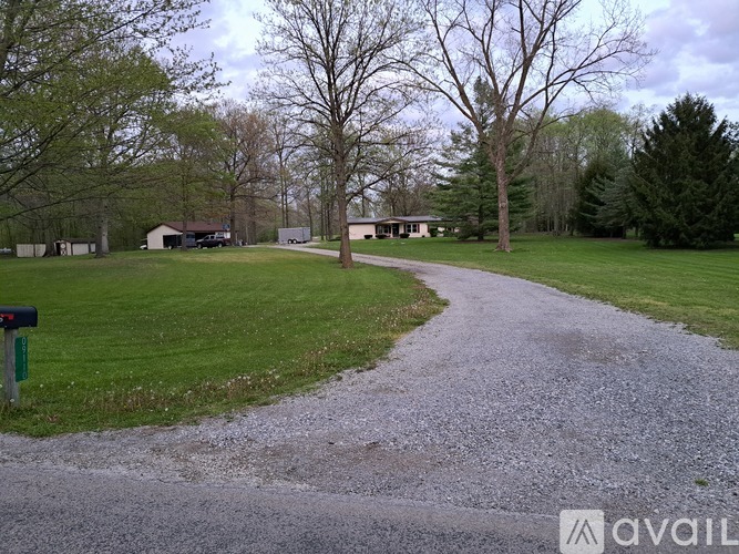 A gravel path leads to a house in a grassy area.