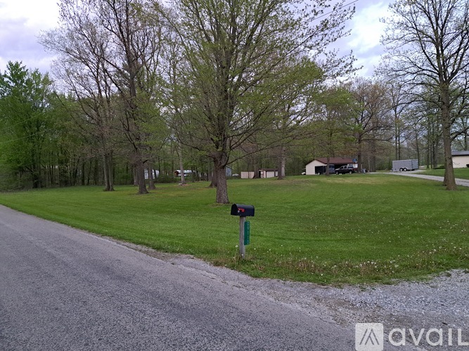 A road with a mailbox and green grass on the side.