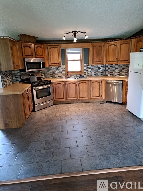 A kitchen with wooden cabinets and a tiled floor.