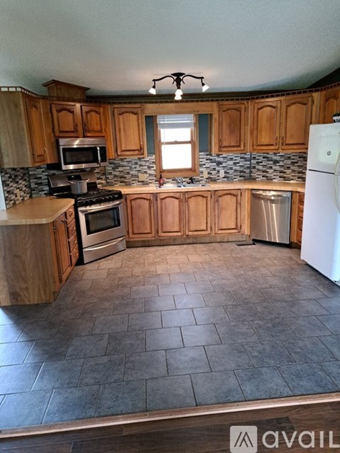 A kitchen with wooden cabinets and a tiled floor.