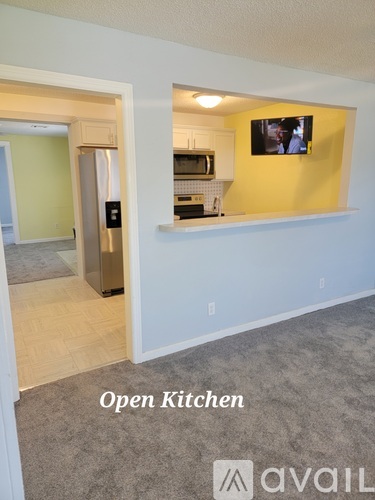 A kitchen with an open refrigerator and a microwave on the counter.