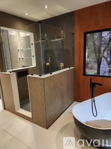 A modern bathroom with a glass shower and a freestanding bathtub.