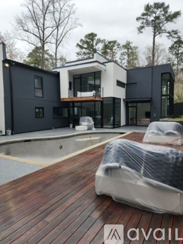 A modern house with a wooden deck and a pool.