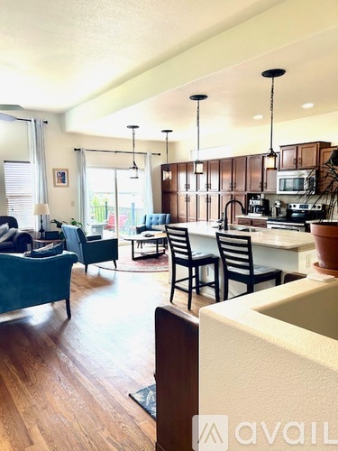 A kitchen with a dining table and chairs is visible.