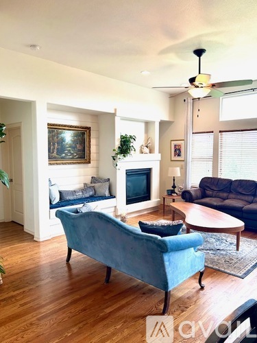 A living room with a blue couch and a fireplace.