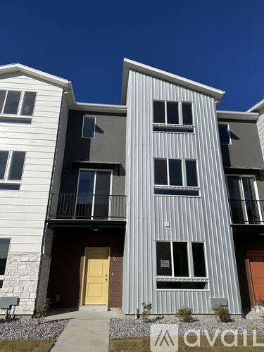 A modern two-story building with a balcony on the second floor.