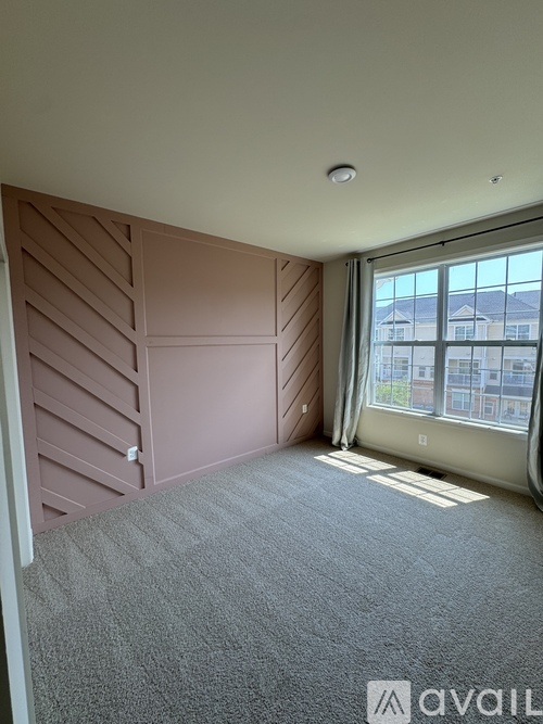 A room with a window and a carpeted floor.