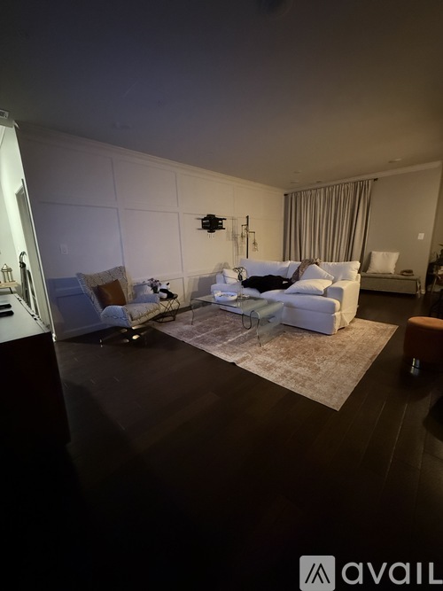 A living room with a white couch and a rug.