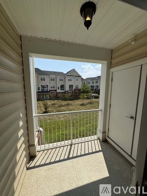 A balcony with a white door and a view of apartment buildings.