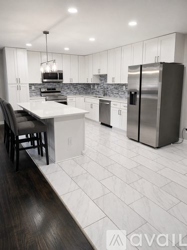 A modern kitchen with a refrigerator, stove, and oven.