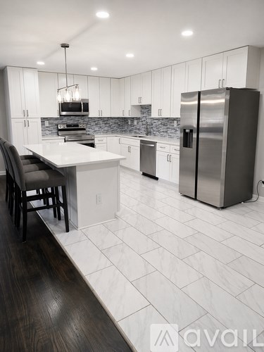 A modern kitchen with a refrigerator, stove, and oven.