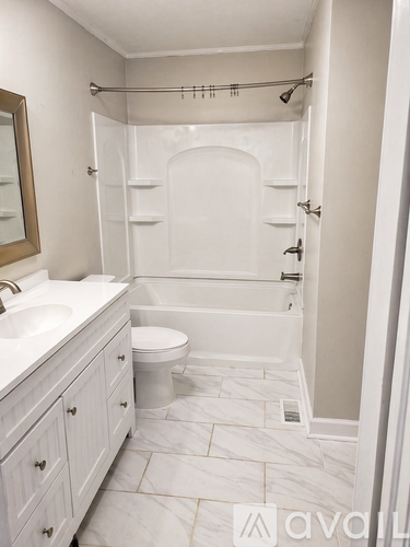 A white bathroom with a toilet, sink, and tub.