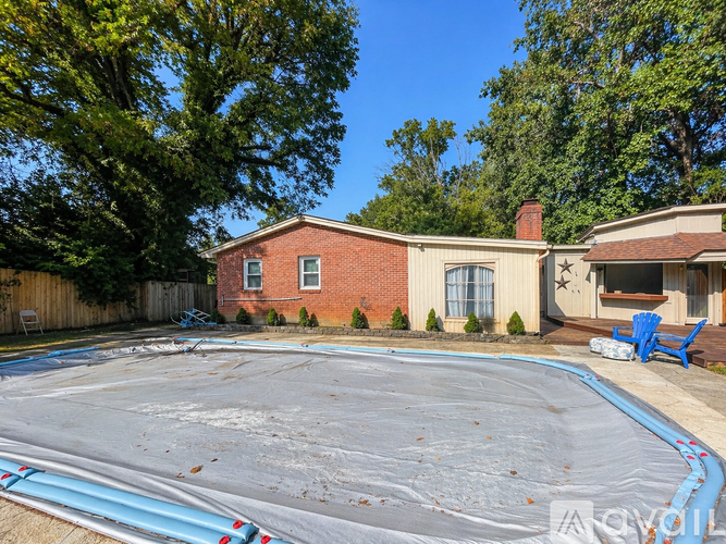 A backyard with a pool and a house.