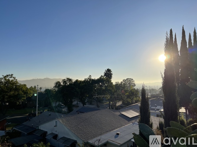 A sunny day in a residential area with houses and trees.