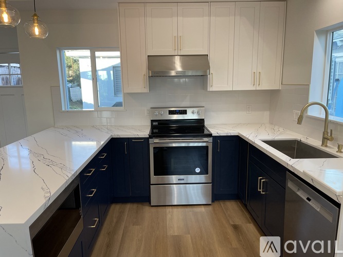 A kitchen with a stainless steel oven and black cabinets.