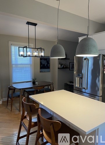 A kitchen with a table and chairs.