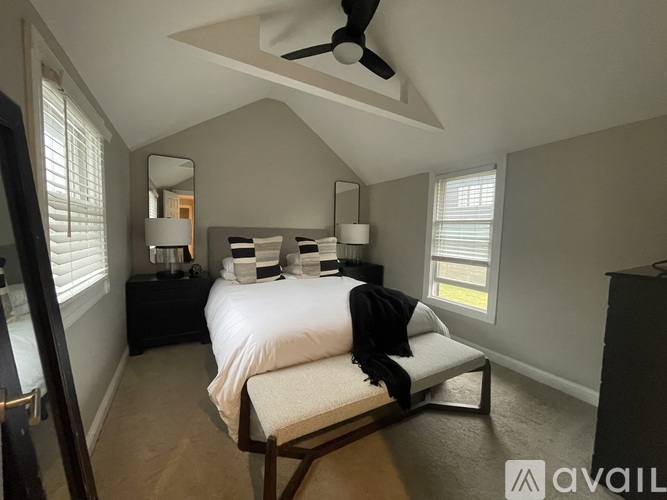 A bedroom with a bed, nightstands, and a ceiling fan.