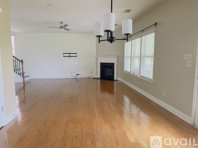 A spacious living room with wooden floors and a fireplace.