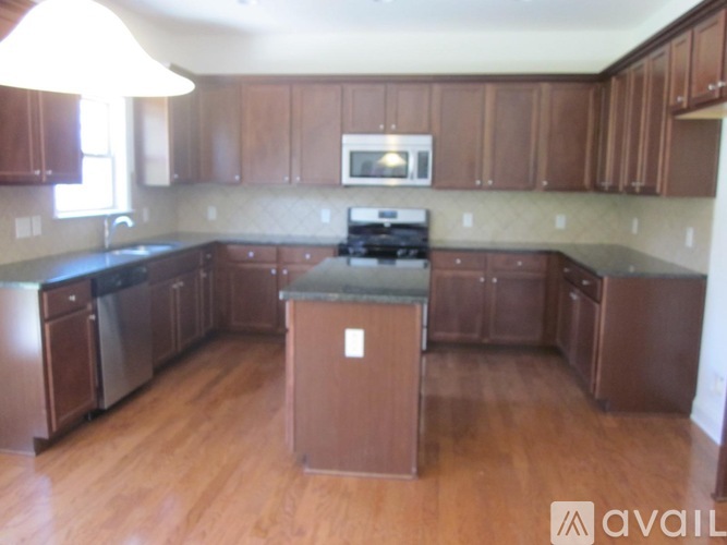 A kitchen with wooden cabinets and a stove top oven.
