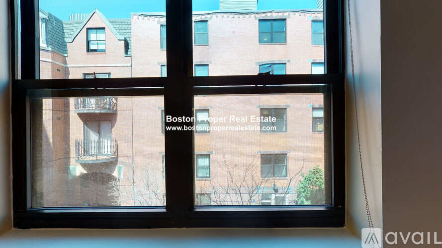 A window with a view of a building and trees outside.