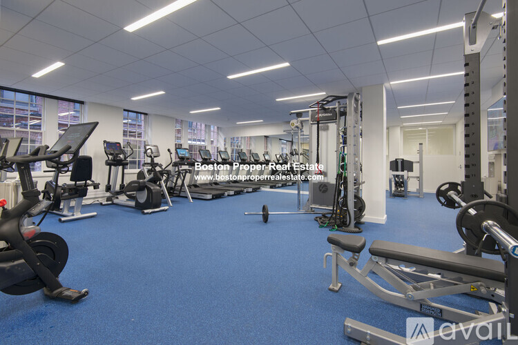 A gym with a variety of equipment including treadmills, weights, and exercise machines.