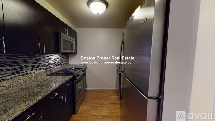A kitchen with a granite countertop and stainless steel appliances.