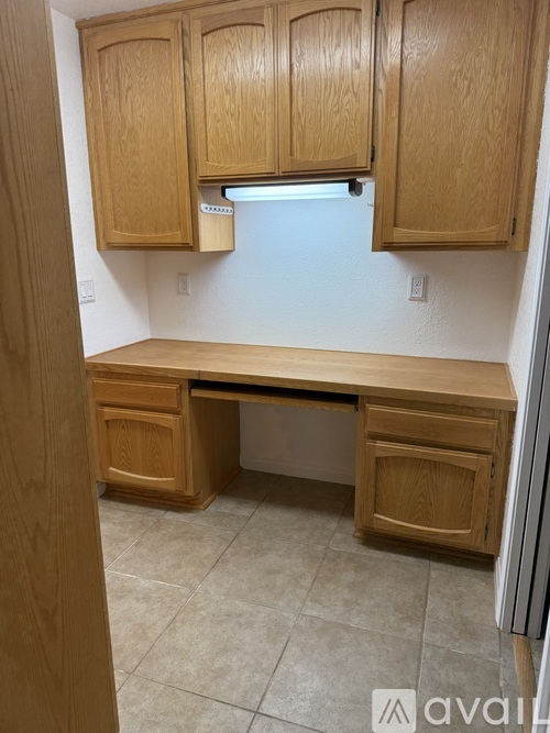 A kitchen with wooden cabinets and a desk.
