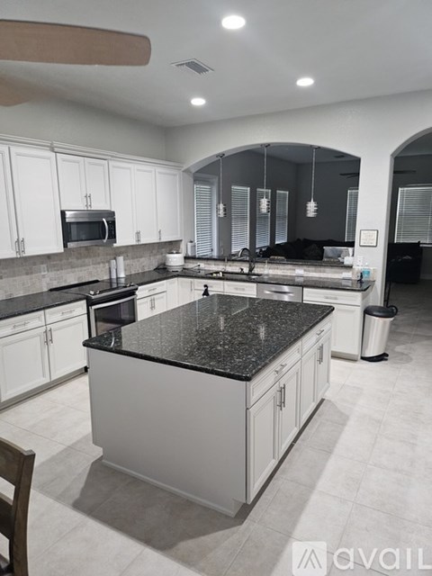 A kitchen with black countertops and white cabinets.