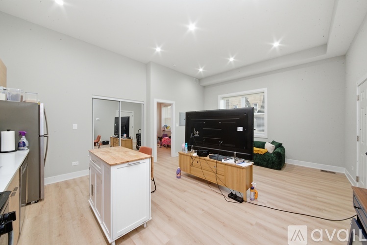 A living room with a television and a kitchenette.