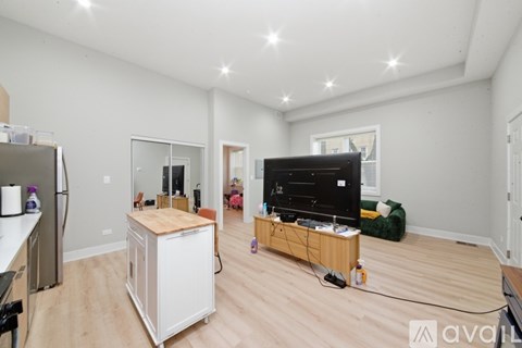 A living room with a television and a kitchenette.