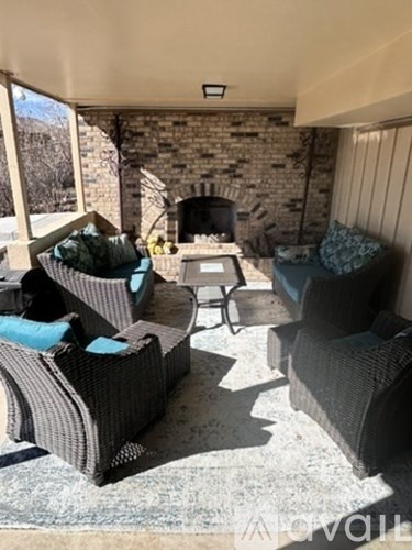 A living room with a stone fireplace and grey couches.