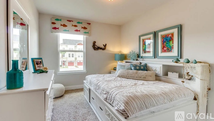 A bedroom with a white bed and a window with a view of buildings outside.